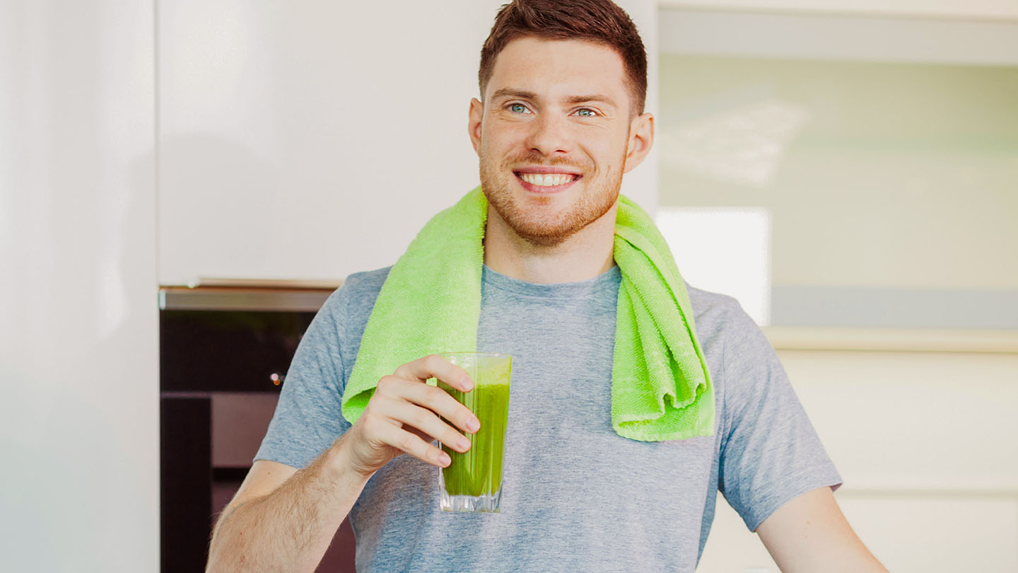 Vīrietis bauda veselīgu zaļo kokteili.