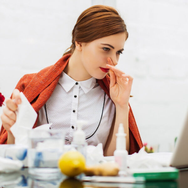 Slima sieviete ar saaukstēšanos birojā.