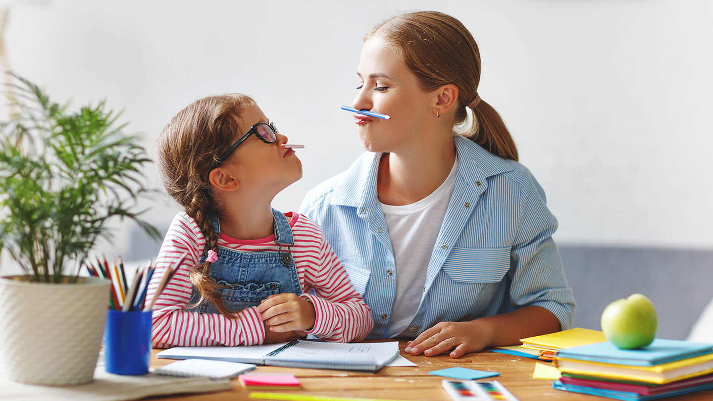 Māsas spēlējas, pildot mājasdarbus.