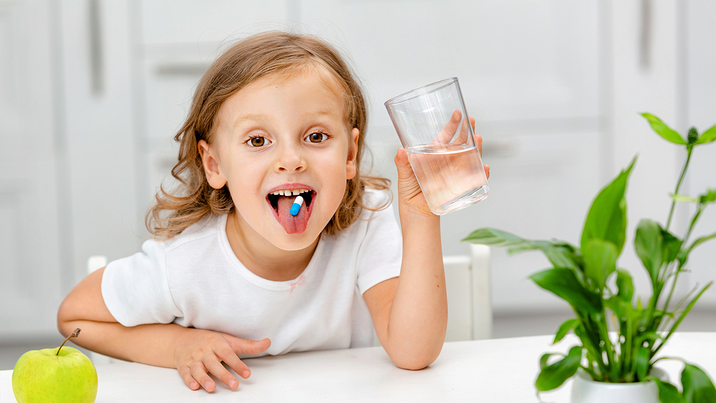 Jauna skolniece lieto uztura bagātinātāju, lai uzlabotu imunitāti.