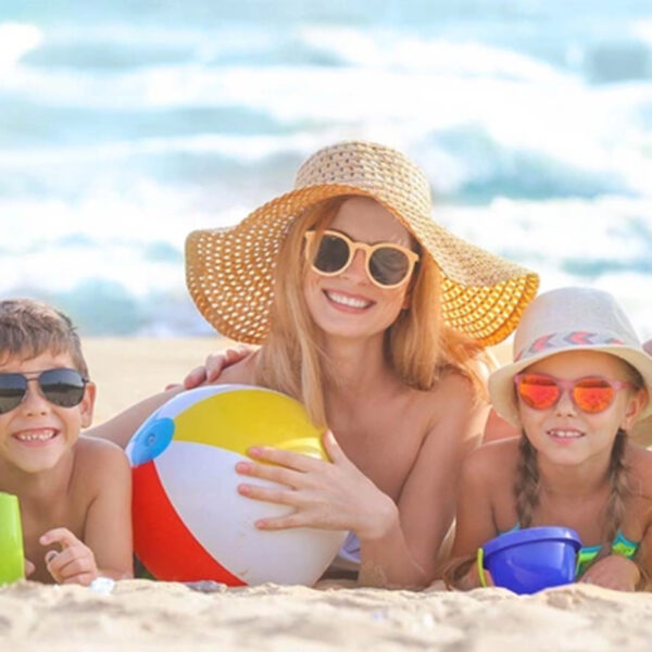 Vasara un bērnu slimības; ģimene pie jūras bauda pludmali un sauli.