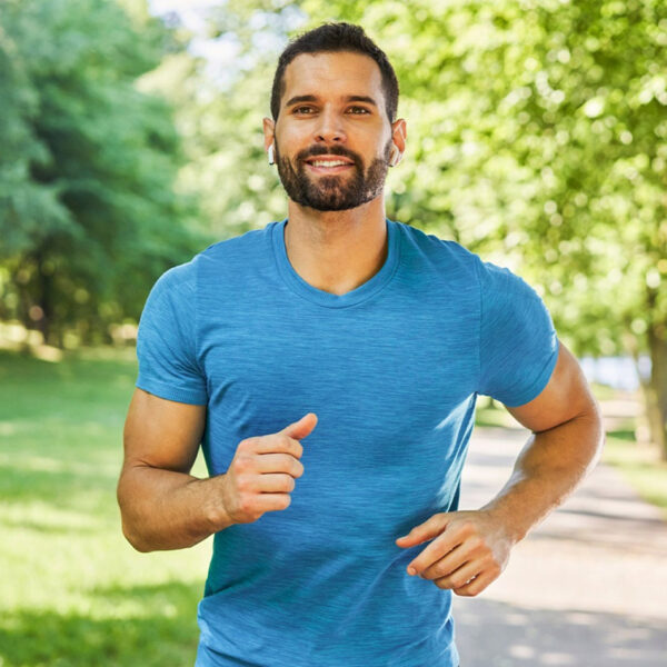 Vīrietis skrien parkā, fiziska aktivitāte.